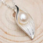ByQueen | Ασημένιο κολιέ 925 Lumière Pearl Leaf με λευκή πέρλα σε κοντινή λήψη