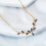 ByQueen | Κολιέ 925 με μπλε ζιργκόν σε σχέδιο φύλλων και χρυσή απόχρωση